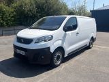 la photo d'une camionnette blanche garée sur un parking