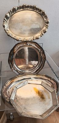 trois plateaux en argent empilés les uns sur les autres sur une table