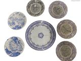 six assiettes bleues et blanches sont disposées en cercle sur une surface blanche