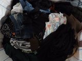 a pile of clothes that is on a bed