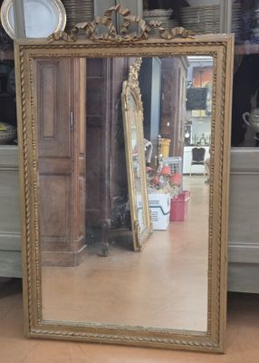 a mirror that is sitting on the floor in front of a dresser