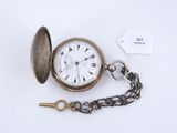 une montre de poche attachée à une chaîne, posée sur une table