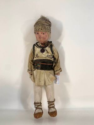 une image représentant une poupée en forme d'homme, coiffée d'un chapeau et chaussée de bottes