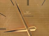 a gold clock that is on display in a glass case
