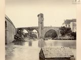 une photo en noir et blanc d'un pont enjambant une rivière