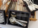 two trays with silverware in them on a table