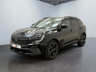 Une voiture noire est garée dans une grande pièce aux murs blancs.
