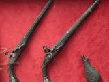 Deux vieilles armes sont exposées dans une vitrine posée sur un socle rouge