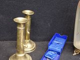 two candles, a candle holder, and other items on the floor