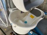 des toilettes blanches avec un couvercle bleu et un seau blanc