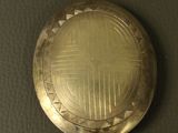 a small gold pocket watch on a black surface