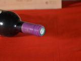 a bottle of wine sitting on a red table cloth