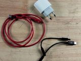 a red and white cord connected to a charger on a wooden table