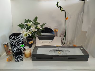une table sur laquelle se trouvent un miroir, un vase, une bougie et des fleurs