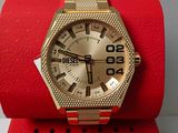 gold watch sitting on a red watch stand on a white surface