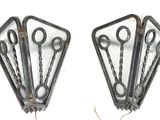 four pairs of scissors hanging from the side of a wall