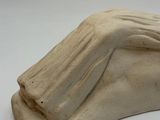 sculpture of a woman ' s hand resting on a foot