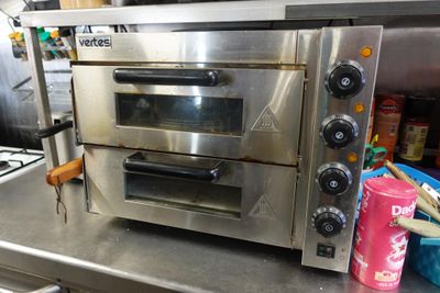 un four argenté posé sur un plan de travail dans une cuisine