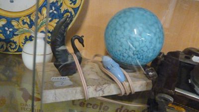une vitrine en verre contenant une boule bleue et un appareil photo