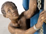 a statue of a man holding a surfboard in his hand