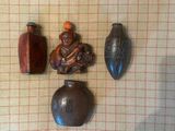 trois vases posés sur une table, avec une petite figurine à côté
