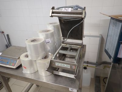 une machine posée sur une table, avec des rouleaux de papier toilette à côté
