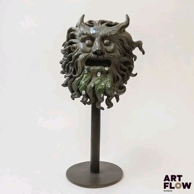 a statue of a green man with a beard on a stand