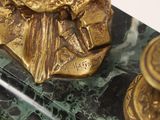 a gold statue of a man on a marble table