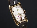a close up of a watch with a brown leather strap