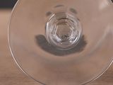 a glass of wine sitting on top of a wooden table