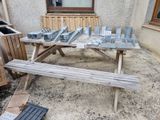 a picnic table that has a bunch of pieces of metal on it