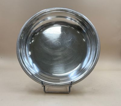 un bol en argent posé sur un socle en métal, sur une table