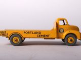 yellow toy truck sitting on top of a white surface next to a white wall