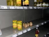 many jars of pickles on the shelves in the store