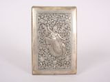 an antique silver cigarette case with a woman on it