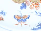 a plate with a butterfly and flowers on it