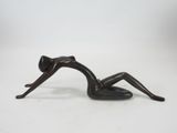 statue of a woman laying on her back on a white surface