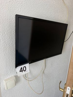 une télévision à écran plat accrochée au mur à côté d'une porte