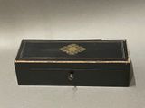 a small black box with a gold decoration on it