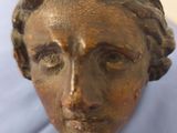 statue représentant la tête d'une femme posée sur un tissu bleu