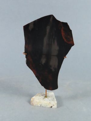 une sculpture représentant un objet noir posé sur un socle blanc
