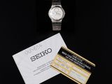 a close up of a watch and a card on a black surface