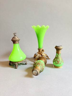 trois vases verts posés les uns à côté des autres sur une table