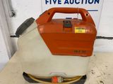 an orange and white sprayer sitting on top of a table