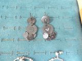 two pairs of earrings sitting on a blue cloth
