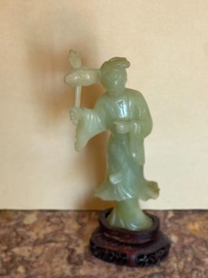 une statue représentant un homme tenant une fleur, posée sur une table