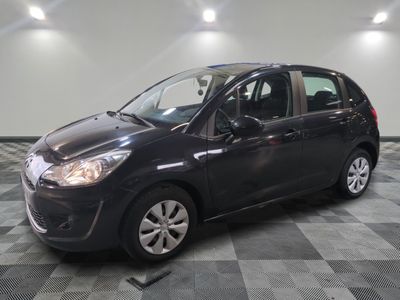 la petite voiture noire est garée sur un carrelage à carreaux
