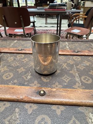 une tasse en métal posée sur un bagage