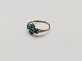 a close up of a gold ring with turquoise stones on it