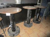 three wooden tables and two metal stools in a room